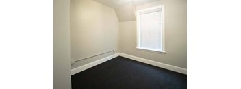 a small room with a black floor and a window