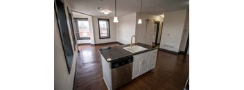 an empty kitchen with a sink in the middle of it