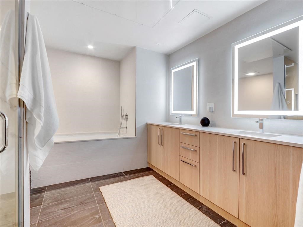 a bathroom with a shower and a sink and a mirror