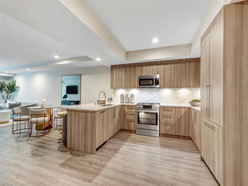 a large kitchen with wooden cabinets and a dining area