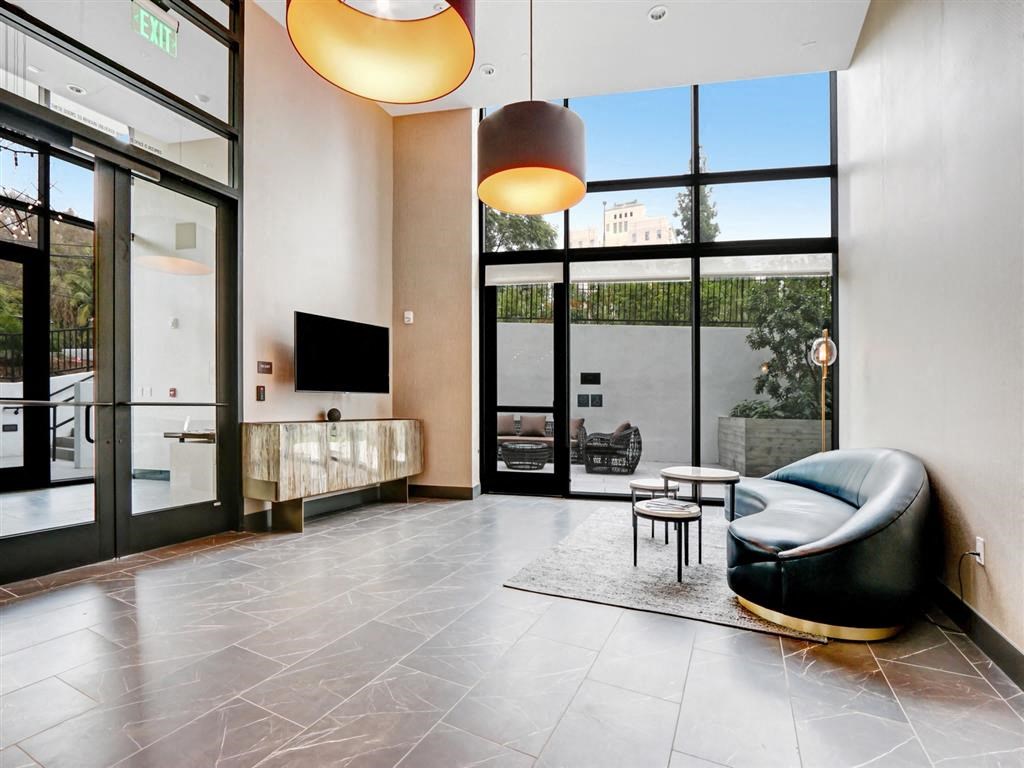 a living room with large windows and a couch and a tv