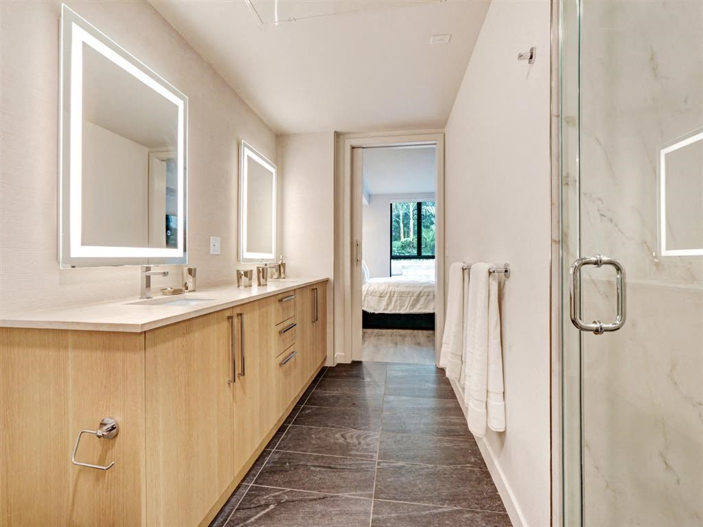 a bathroom with a shower and a sink and a mirror