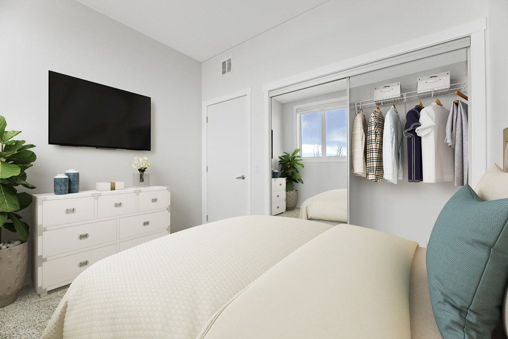 A bedroom with a large bed and a wardrobe with clothes hanging on it.