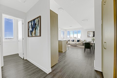 A living room with a grey floor and a painting on the wall.