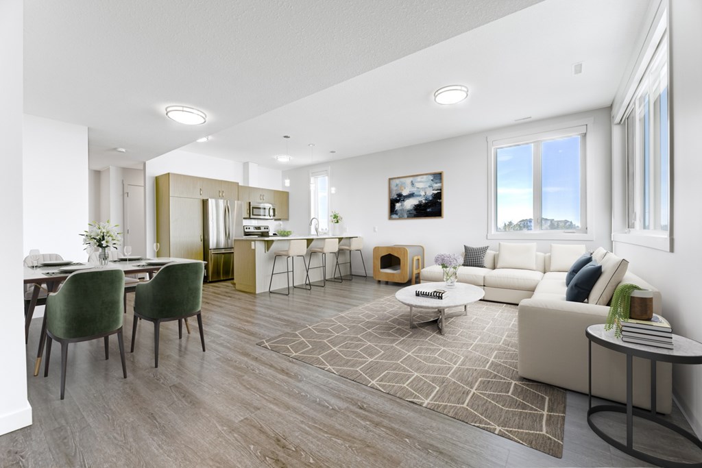 A modern living room with a dining area and a kitchen in the background.