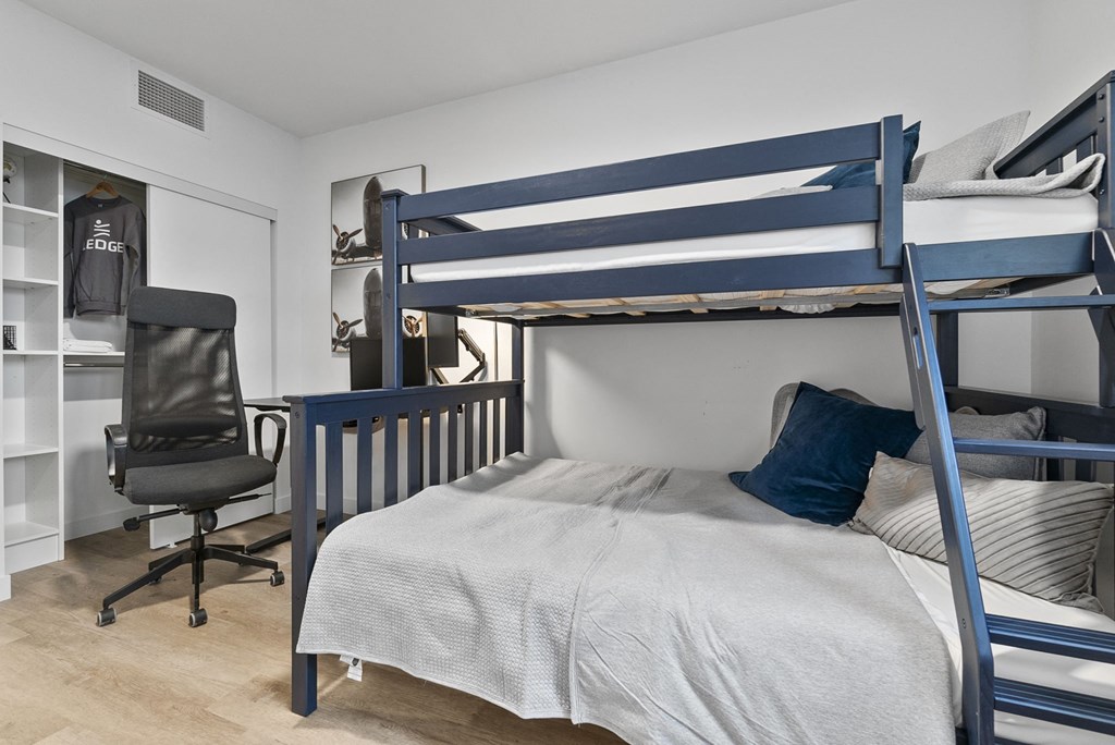 a bedroom with a bunk bed and a desk