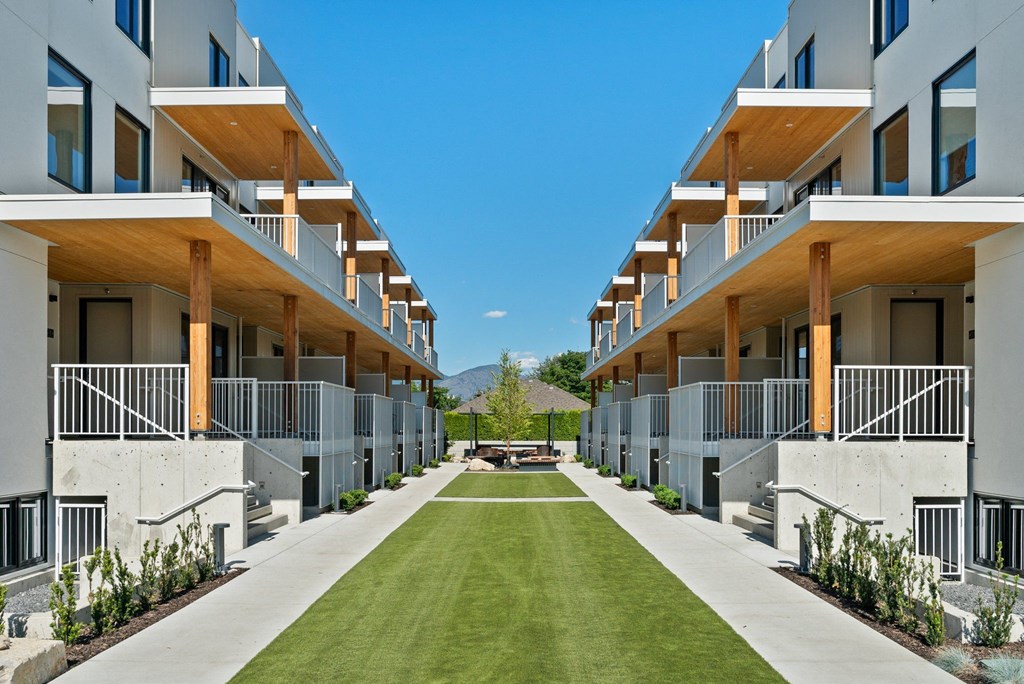 a grassy area in the middle of a row of apartment buildings