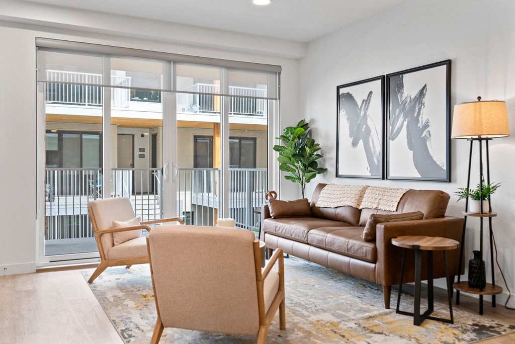 a living room with a couch chairs and a floor to ceiling window