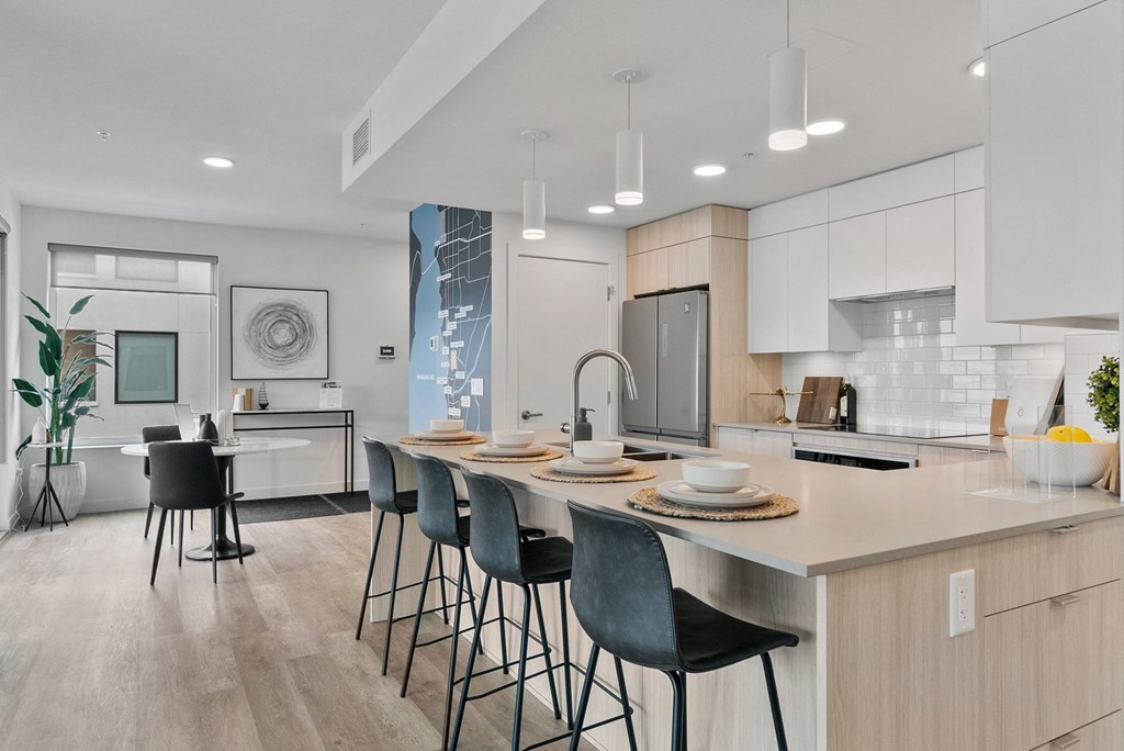 a kitchen with an island and stools in a 555 waverly unit