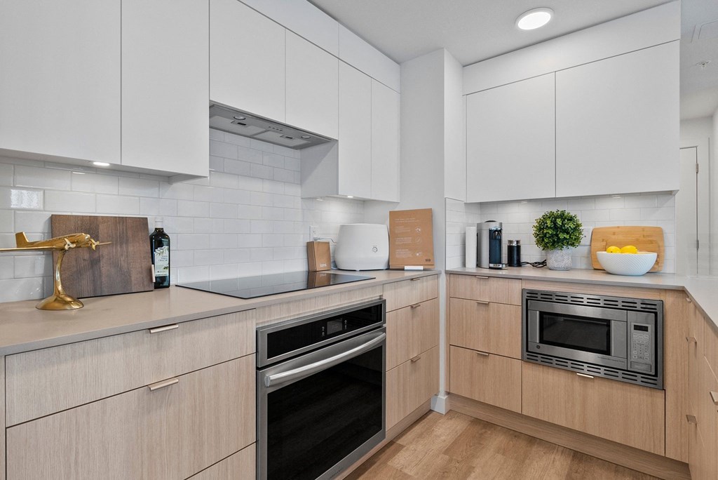 a kitchen with white cabinets and a wooden floor