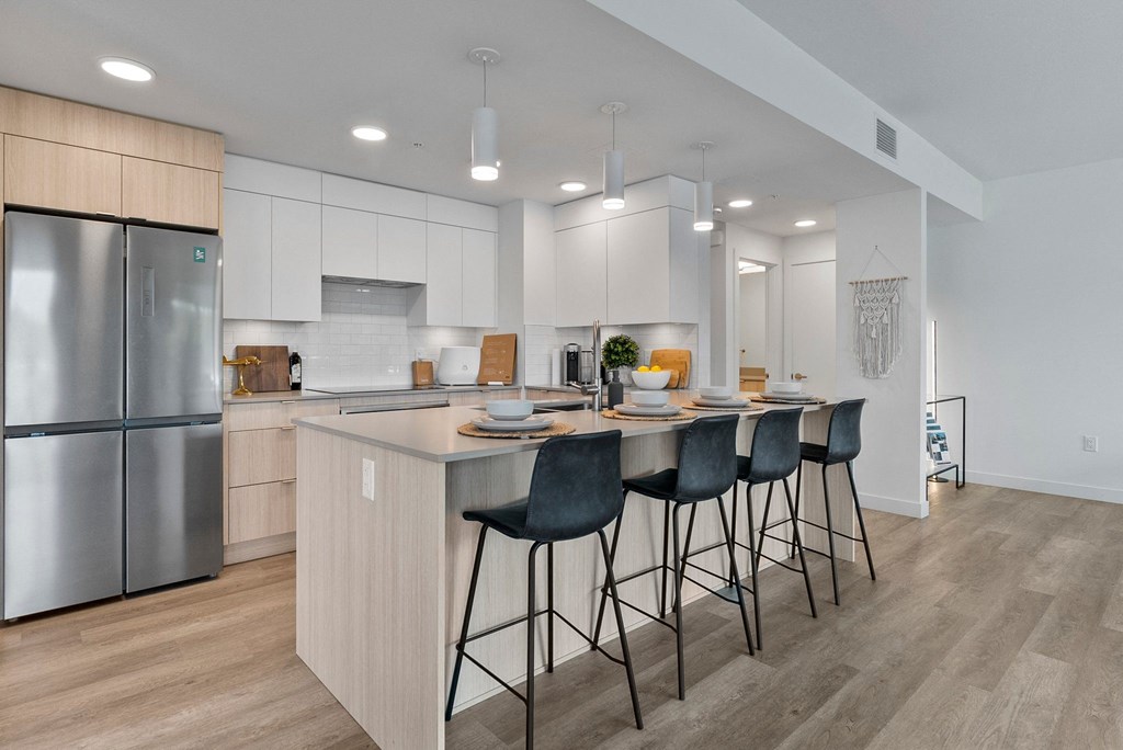 a kitchen with white cabinets and a large island with a breakfast bar