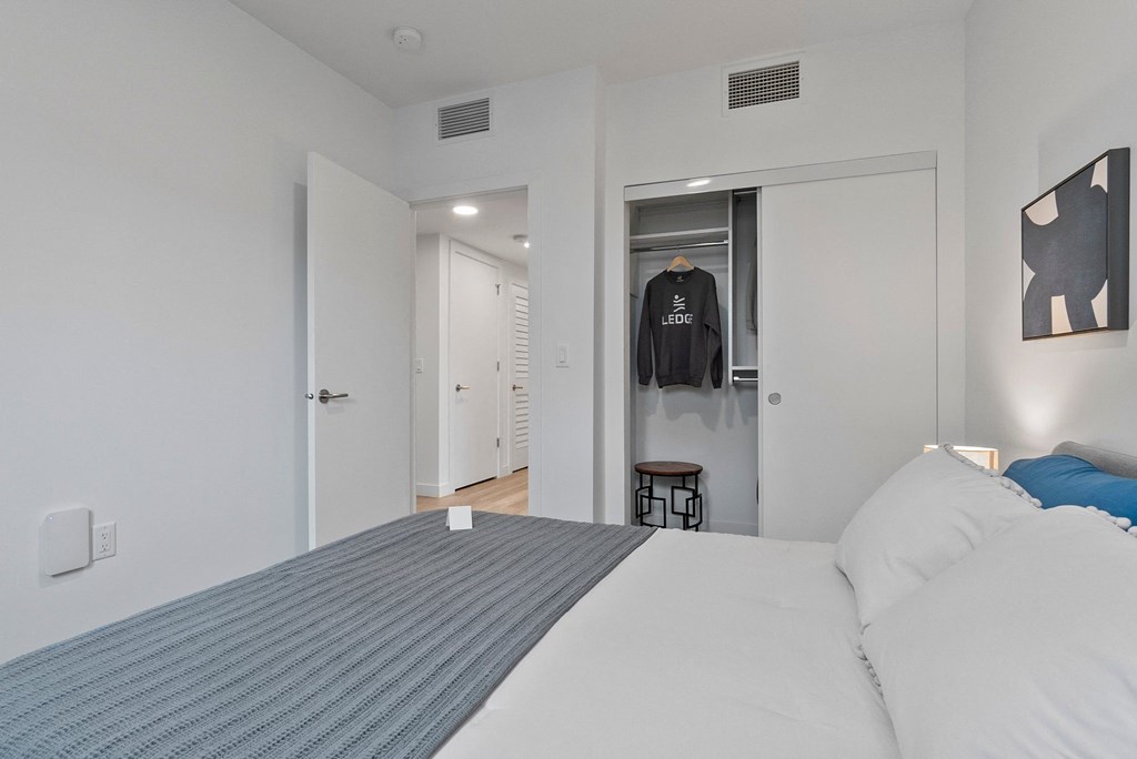 a bedroom with a large bed and white walls