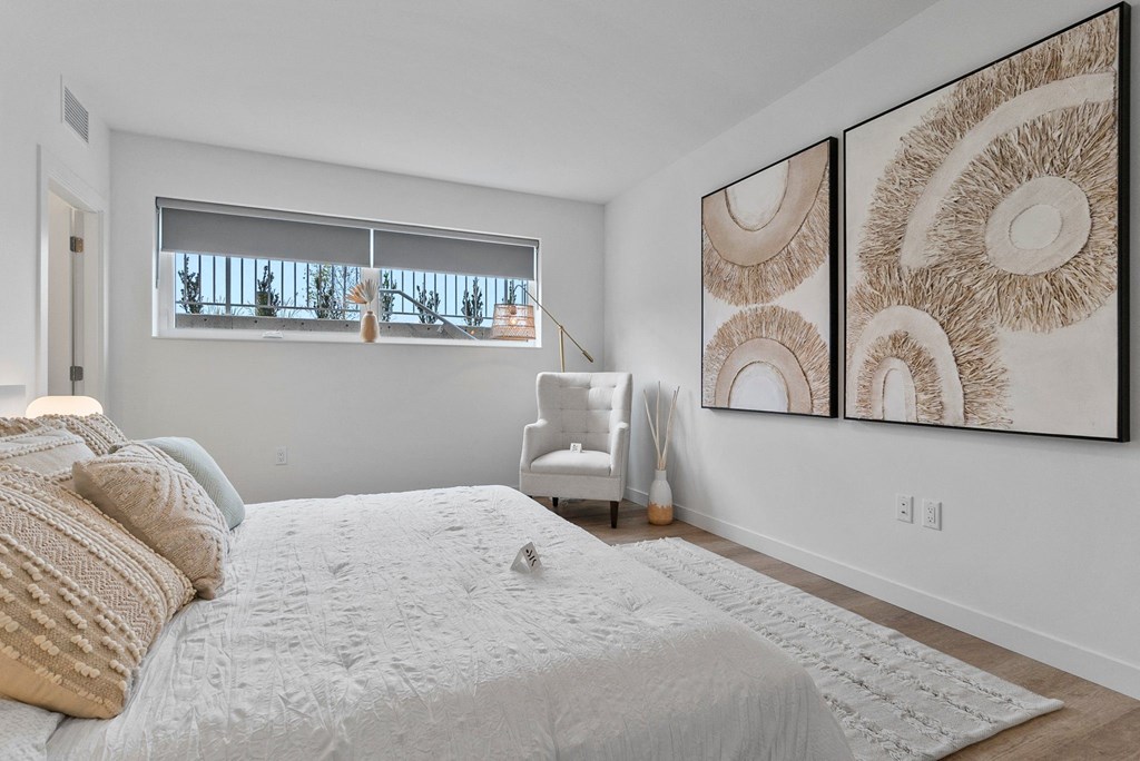a bedroom with a large bed and two large pictures on the wall