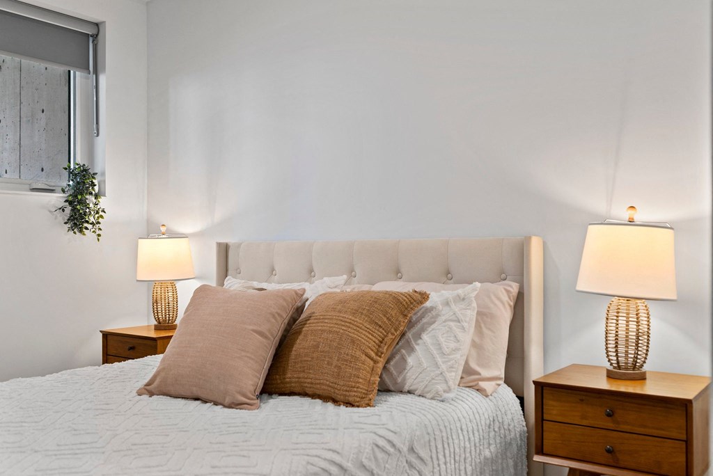 a bedroom with a bed and two night stands with lamps