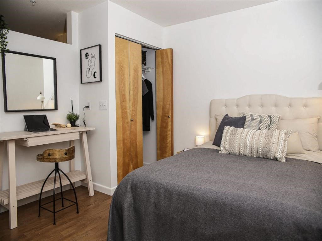 a bedroom with a bed and a desk and a mirror