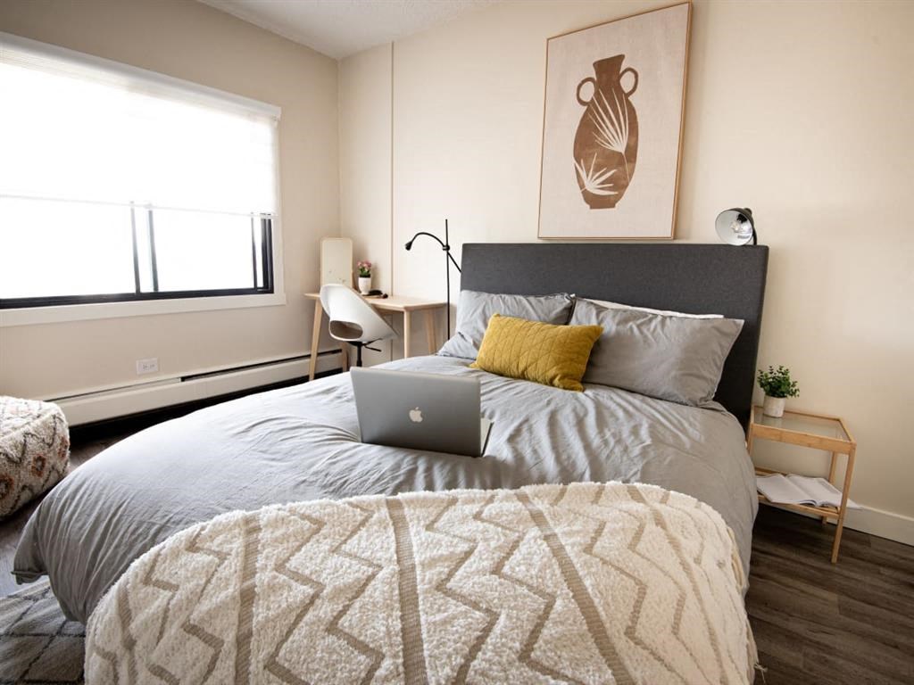 a bedroom with a bed with a laptop on it