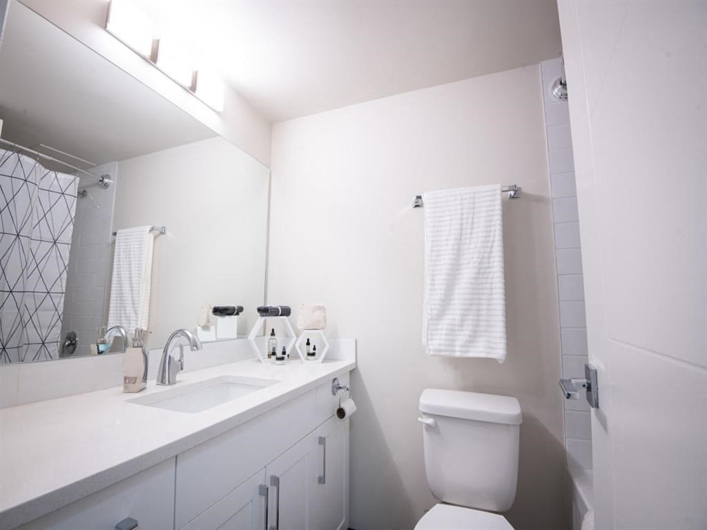a white bathroom with a toilet and a sink