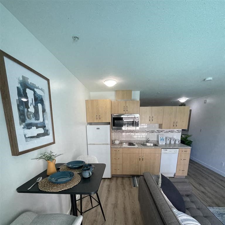 an open kitchen and living room with a black table