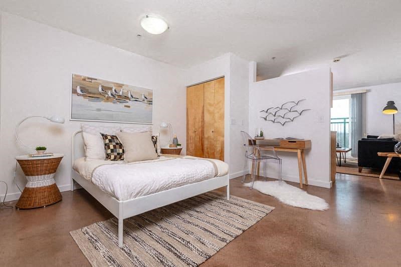 a bedroom with a white bed and a desk