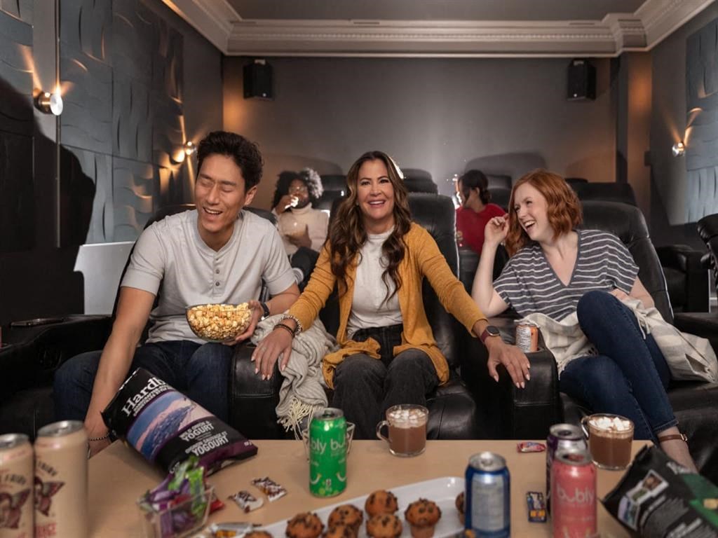 a group of people sitting in a living room watching a movie