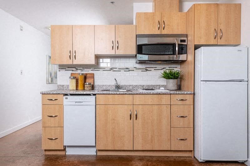 a kitchen with white appliances and wooden cabinets
