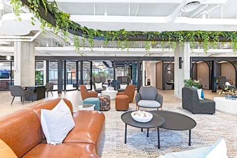 A living room with a brown leather couch and a round table.