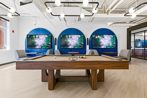 A pool table with a blue screen behind it.