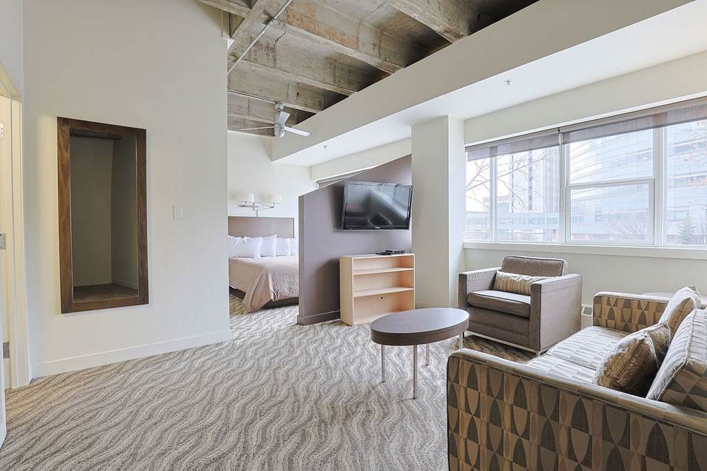 a living room in a hotel room with a couch and a table