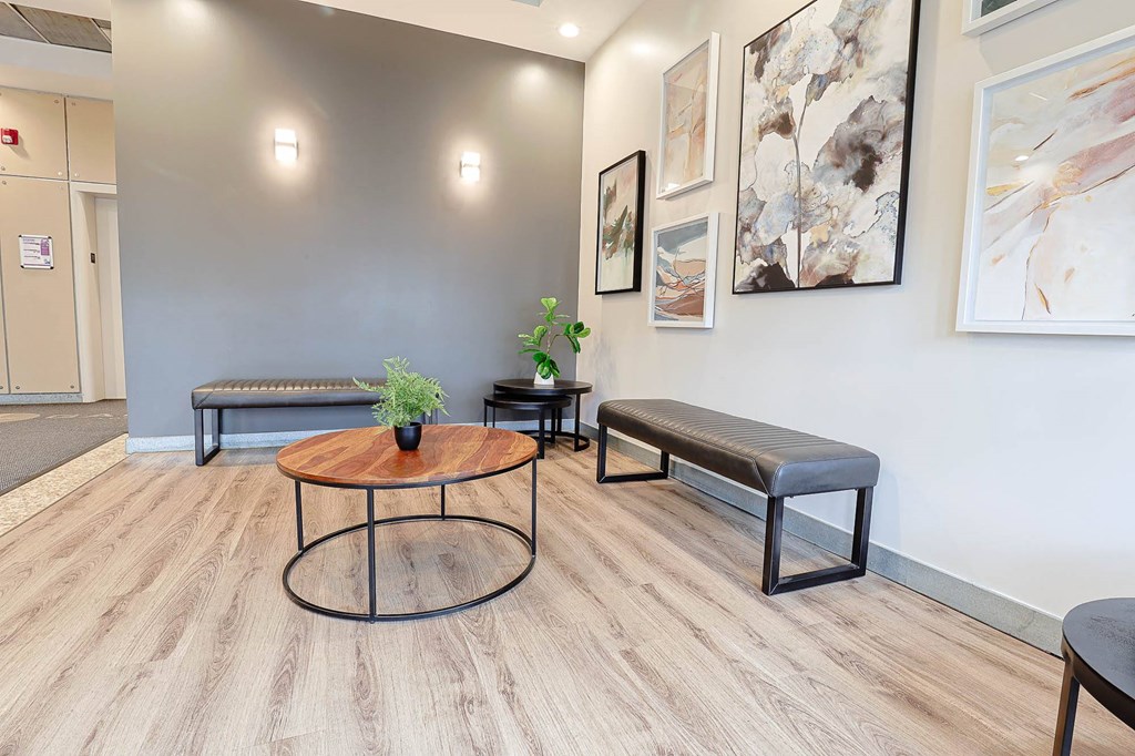 a room with benches and a table and paintings on the wall