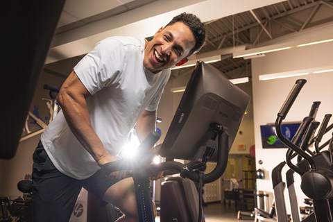 A man is exercising on a stationary bike in a gym.