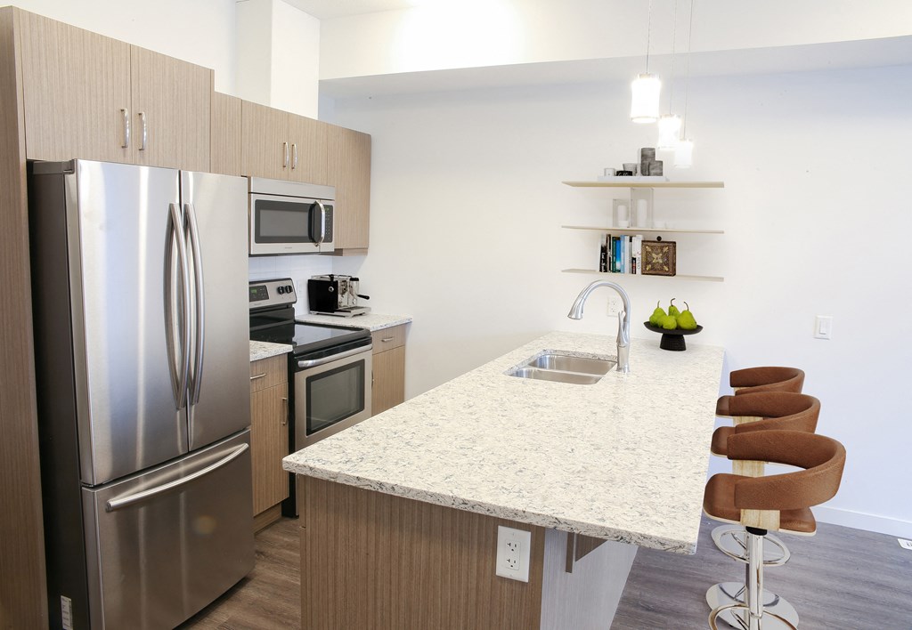 a kitchen with stainless steel appliances and a marble counter top