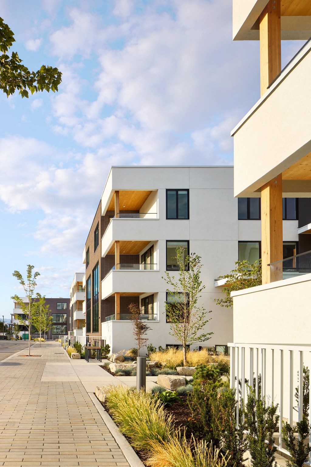 A modern building with a white facade and wooden accents.
