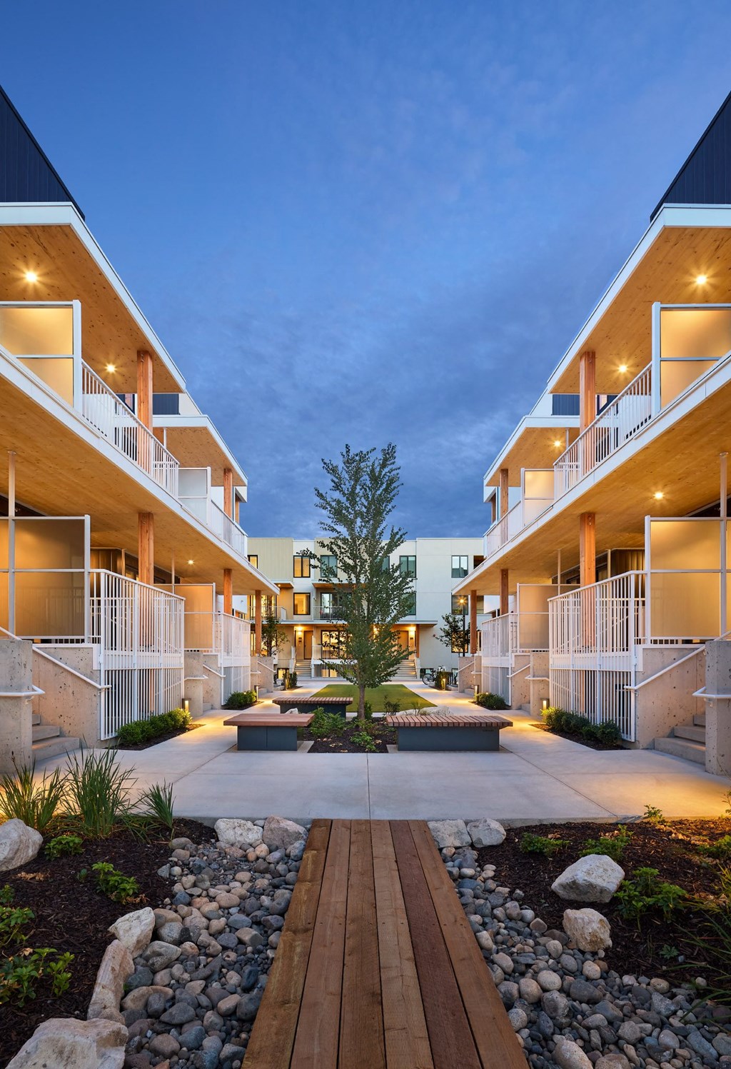 A modern apartment complex with a central courtyard and landscaping.