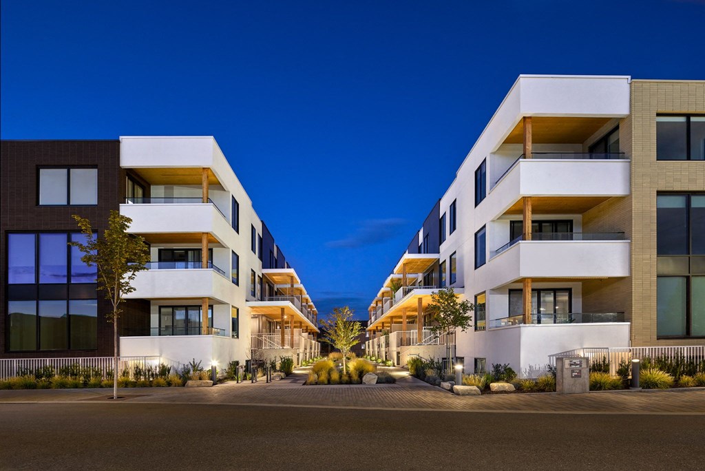 A modern apartment building with balconies and large windows.