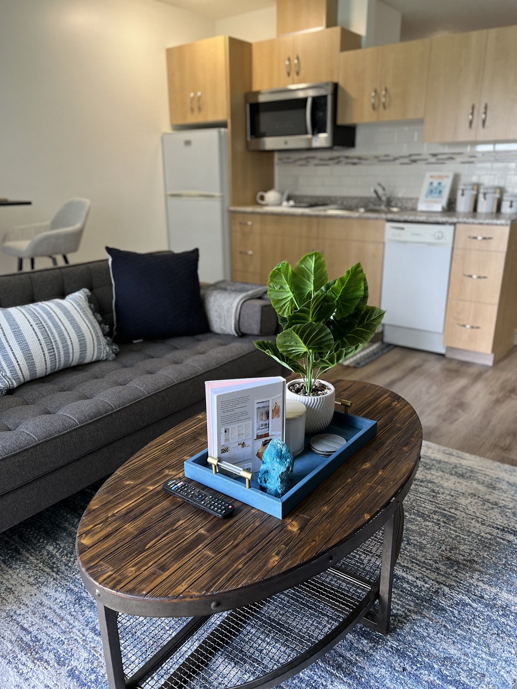 a living room with a couch a table and a kitchen in the background