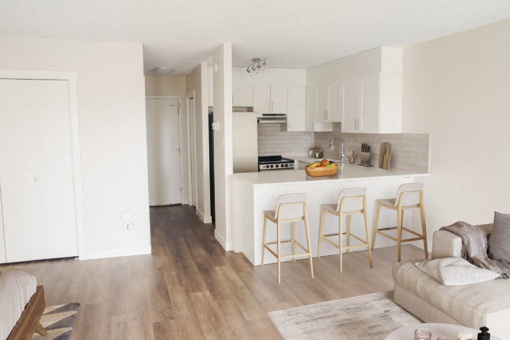 a kitchen with a white counter top and a living room