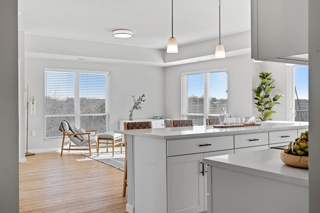 an open kitchen and dining room with white cabinets and white counter tops