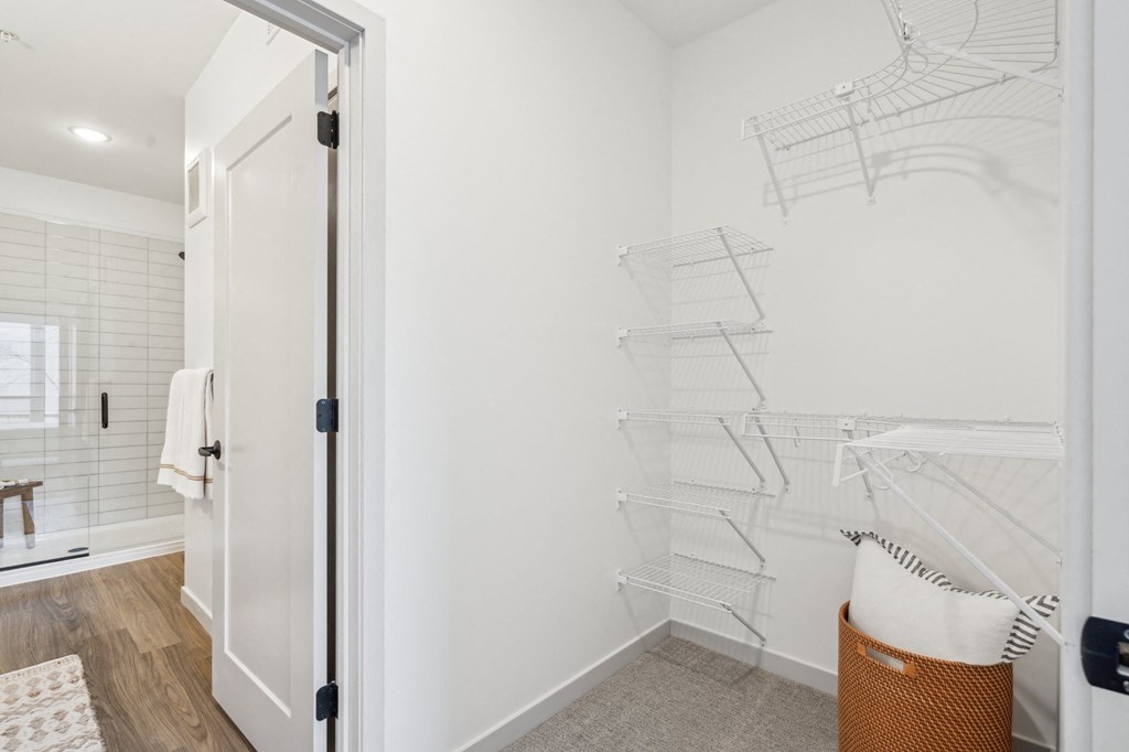A white laundry room with a white door and a white wall.