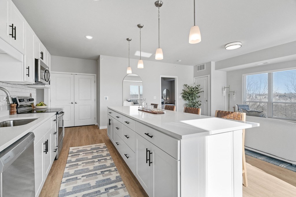 a large kitchen with white cabinets and a large island
