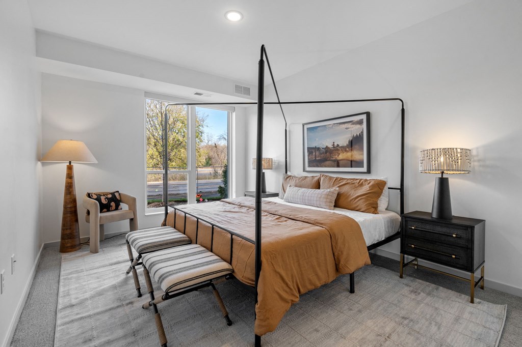 a bedroom with a bed and a large window