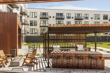 a patio with a table and chairs in front of an apartment building