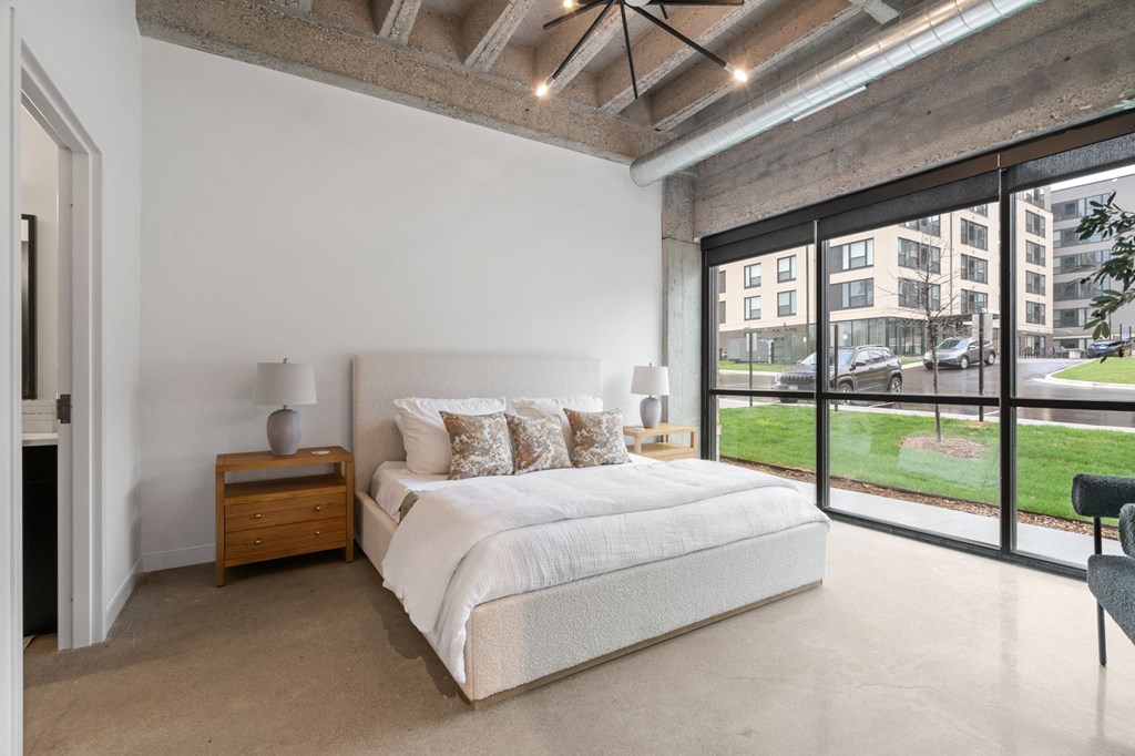 a bedroom with a bed and a large window