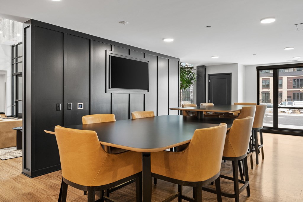 a coworking space with a table and chairs and a television