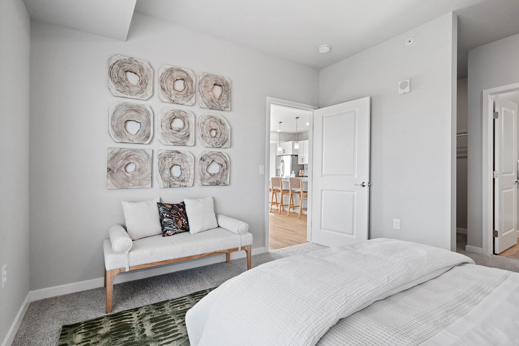 a white bedroom with a bed and a couch