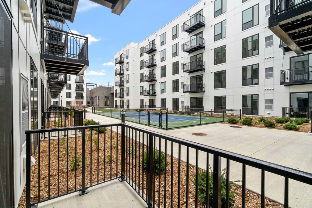 an apartment building with a tennis court in front of it