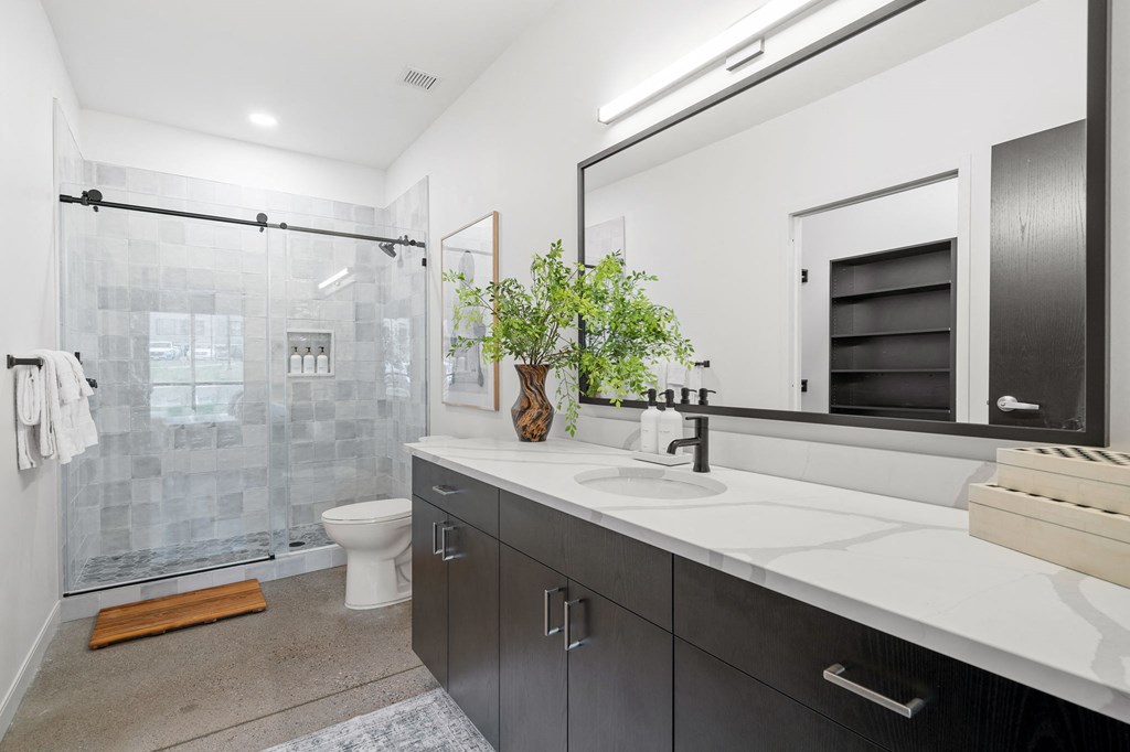 a bathroom with a sink and a shower and a toilet