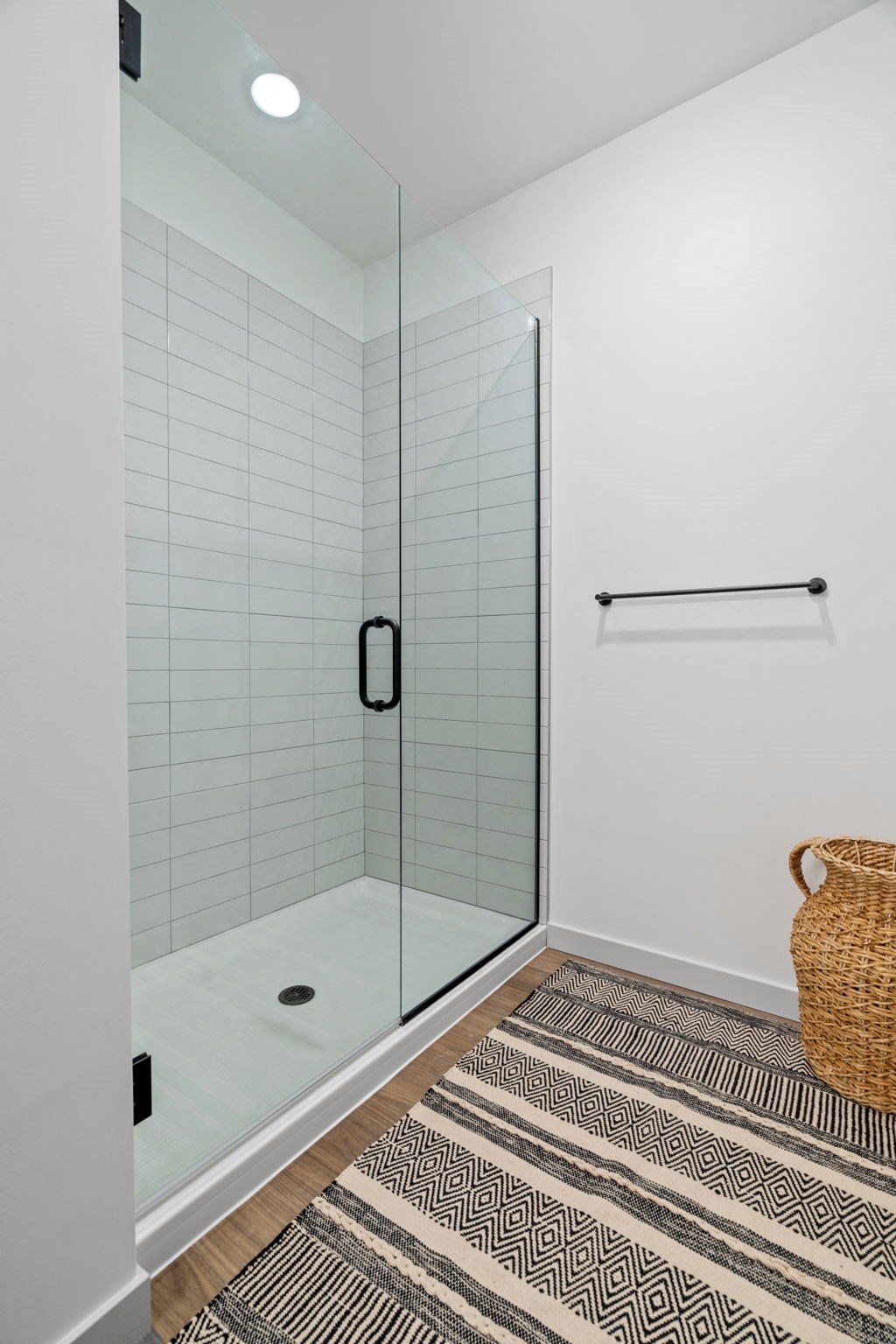 a shower with a glass door in a white bathroom