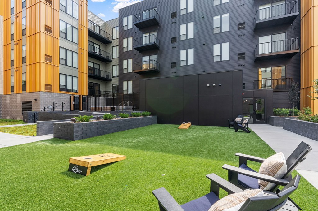 A modern outdoor seating area with a bench and chairs.