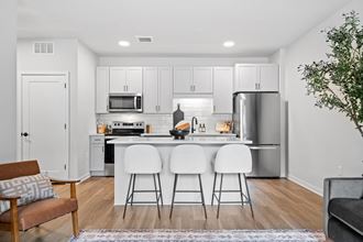 a kitchen with white cabinets and a island with three stools