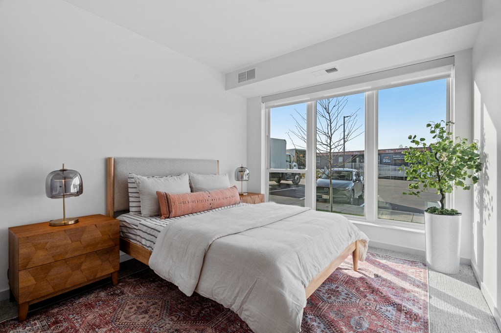 a bedroom with a bed and a large window